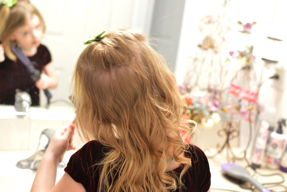 little girl curling her hair