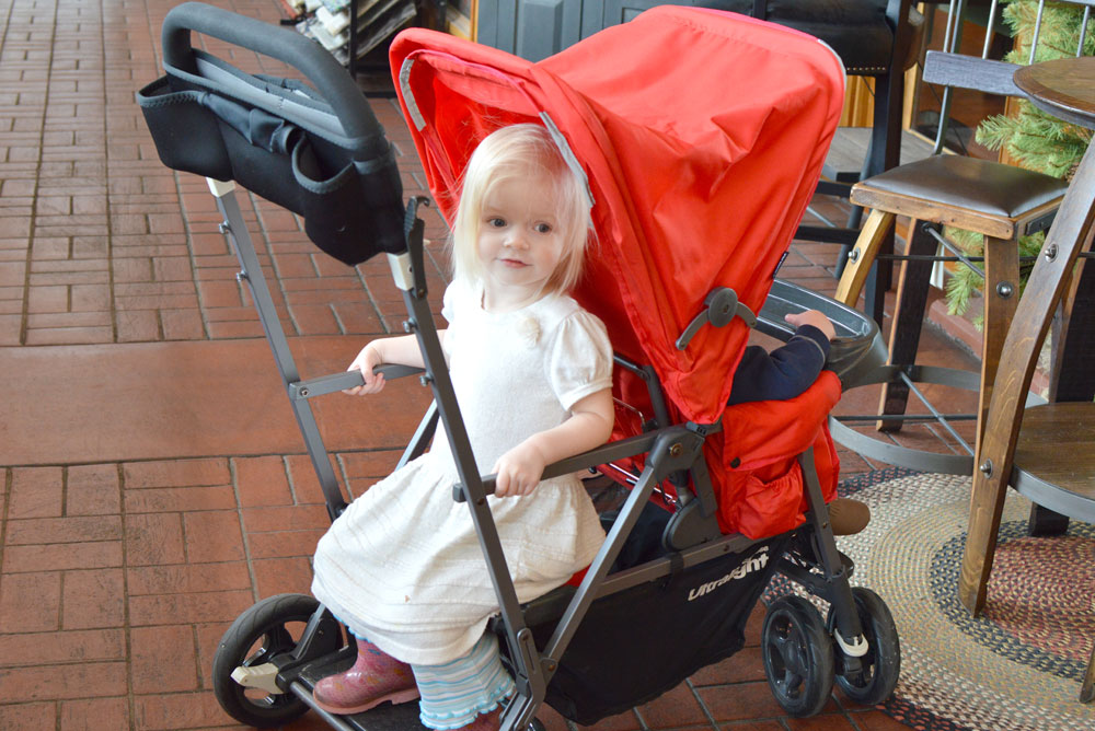 toddler girl sitting Joovy ultralight compact stroller