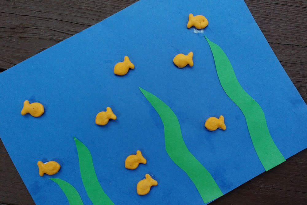 This cute ocean kids craft is easy to make with construction paper and gold fish crackers - Mommy Scene