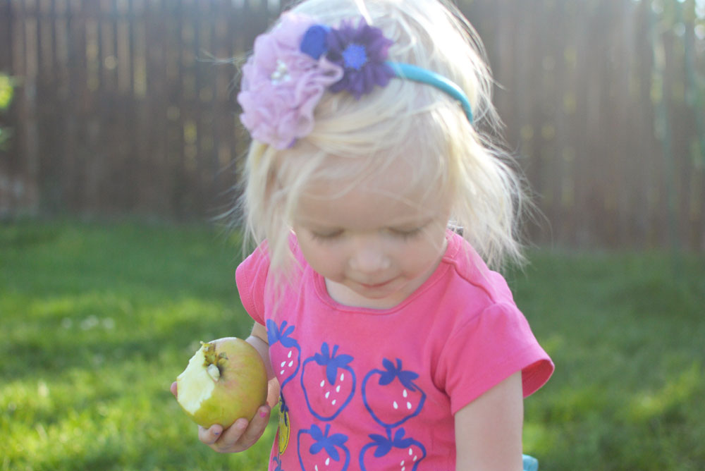 Little girl eating an apple - Mommy Scene