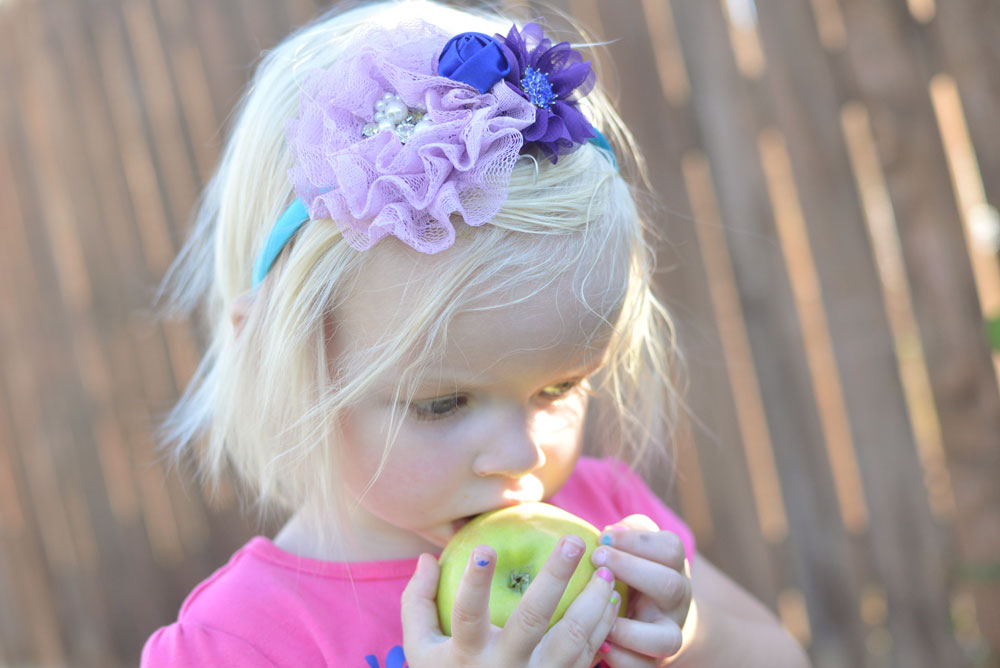 Toddler girl eating an apple - Mommy Scene