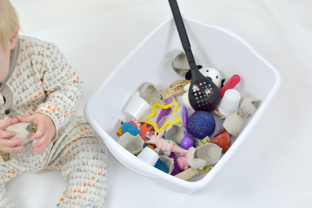 Create a sensory baby box with small baby safe items and toys