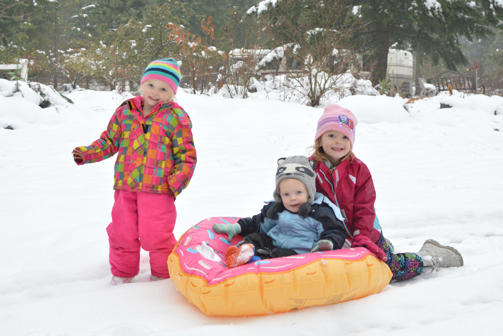 Little kids sledding big mouth doughnut tube - Mommy Scene