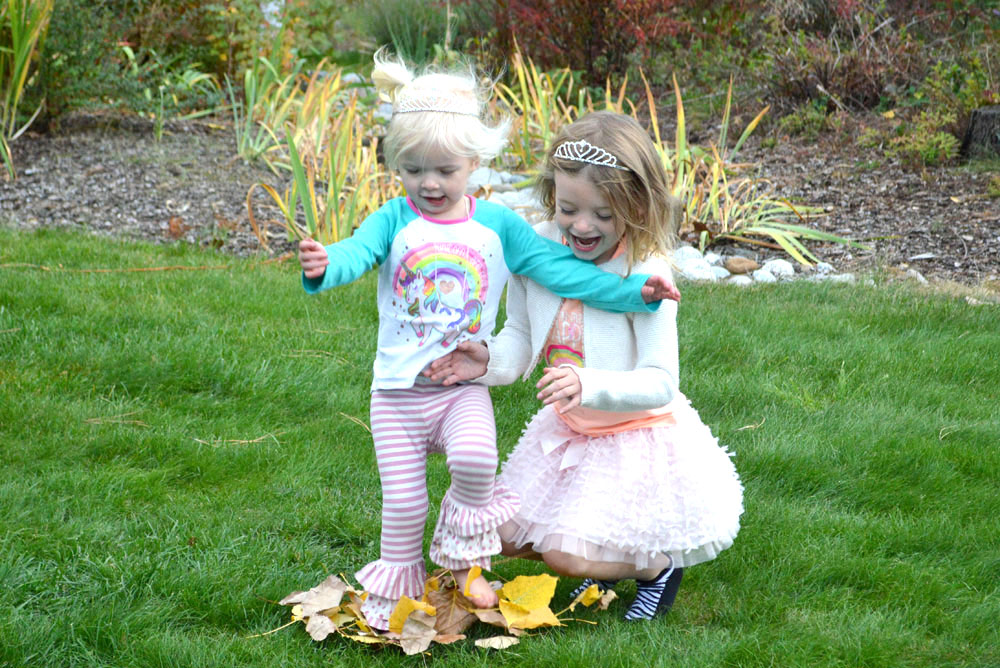 Sisters jumping in the fall leaves