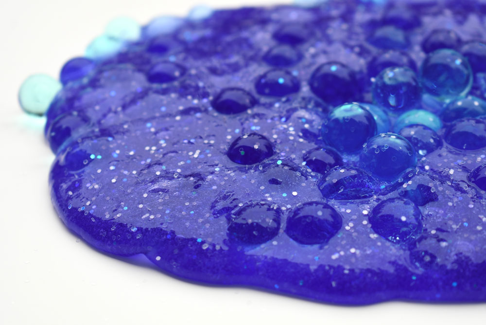 Mix up homemade glitter slime and water beads