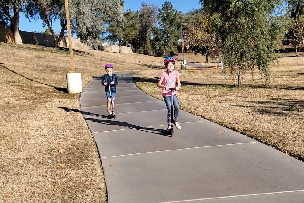 Kids riding scooters at Cactus Park in Scottsdale Arizona