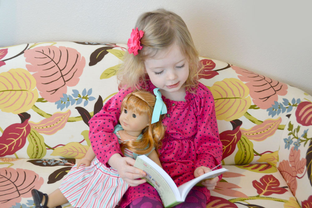 girl reading with American Girl doll Maryellen Larkin