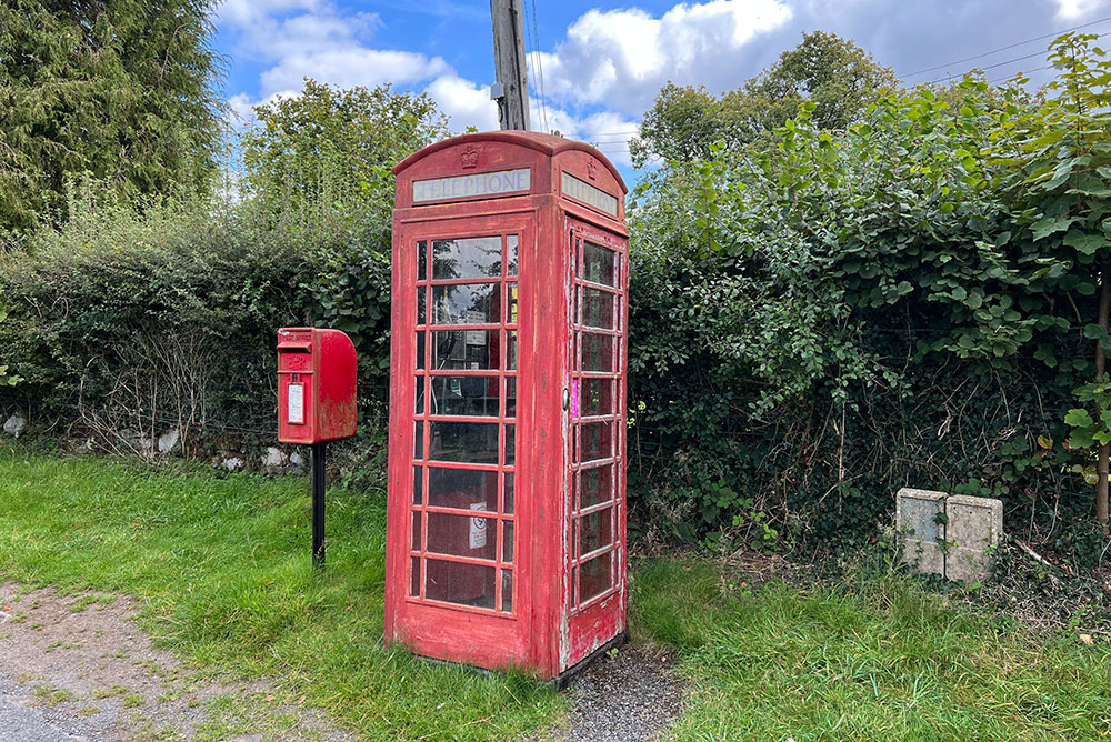 red phone booth along a country road UK