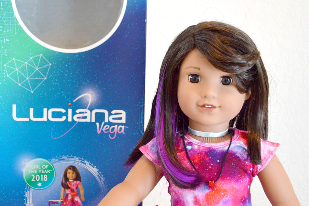AG doll Luciana has brown hair with a purple streak, and space inspired dress